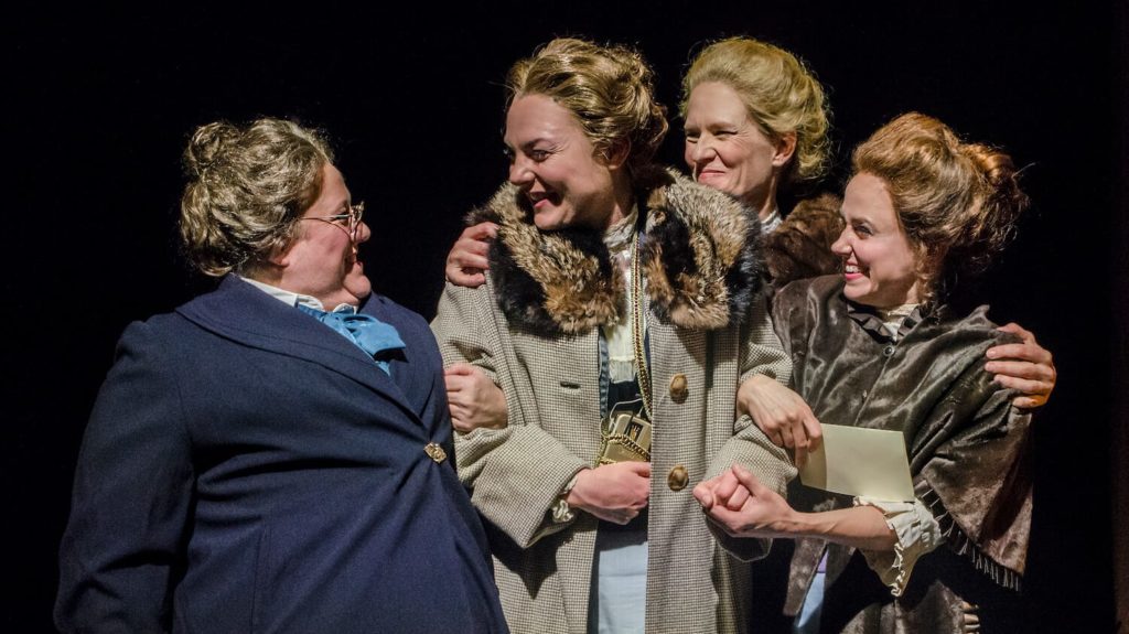 Four women embrace joyfully